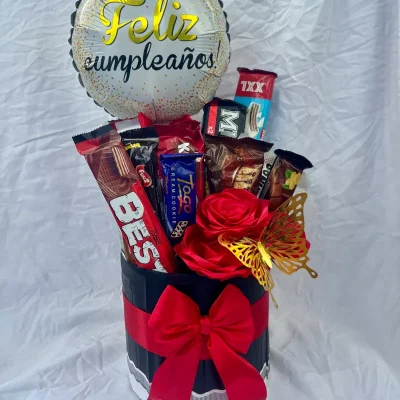 Caja cilíndrica con flores y confituras variadas