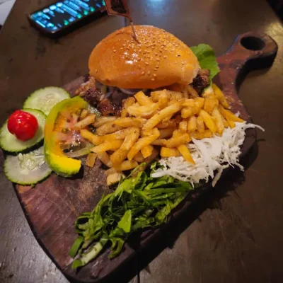 Pan con bistec, papas fritas y vegetales.