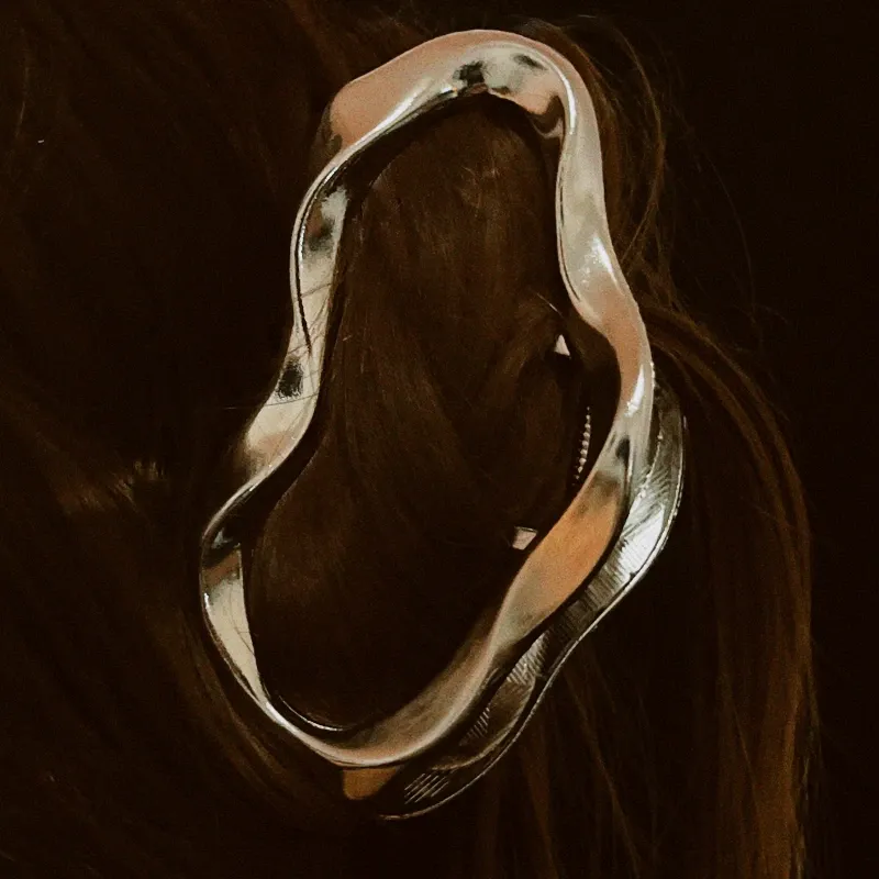 Pinza plateada ovalada asimétrica