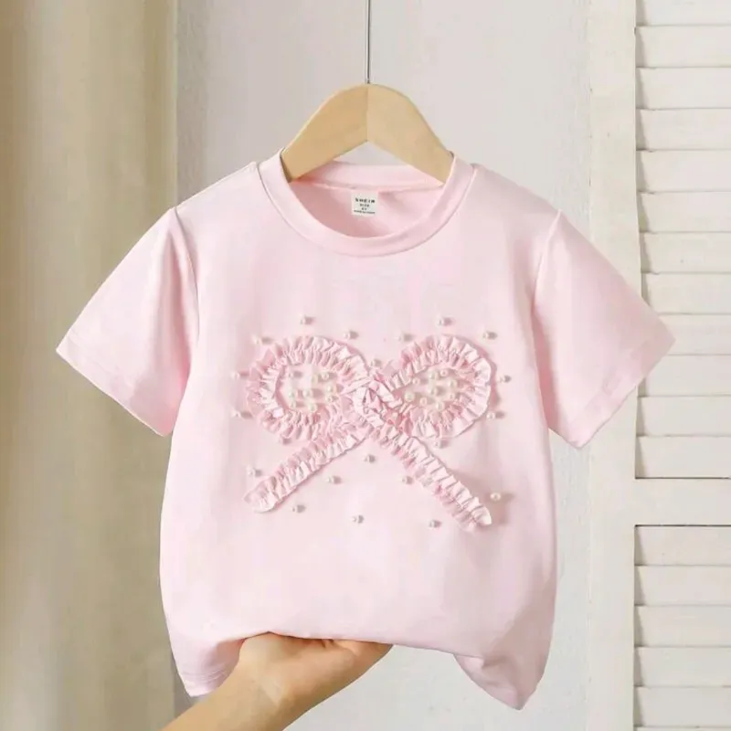 Camiseta rosa con lazo perlas