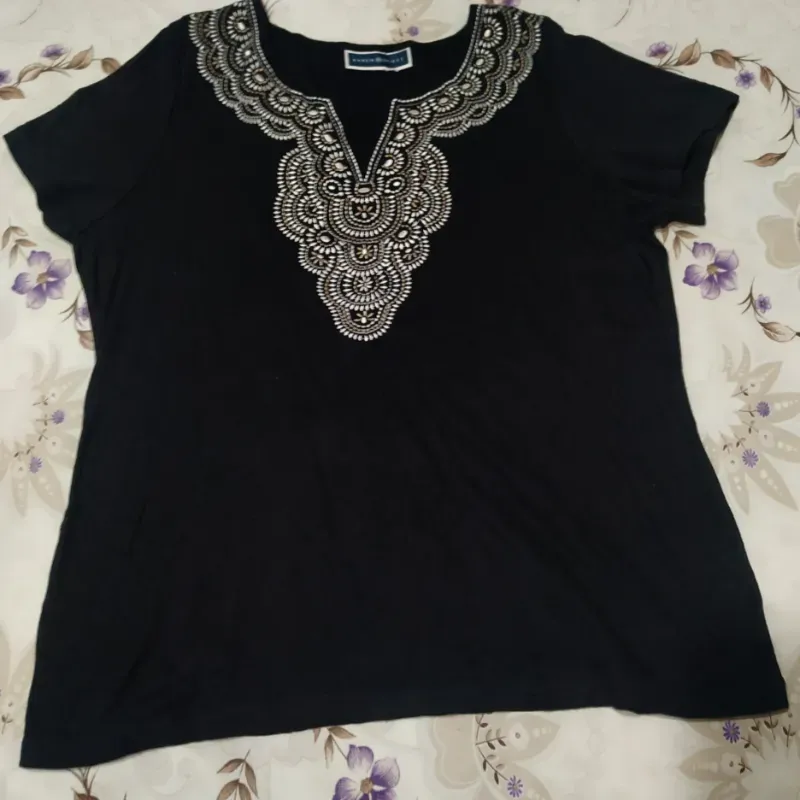 Blusa negra con bordado blanco.