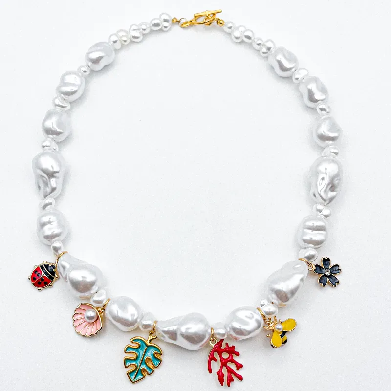 Collar con perlas artificiales y dijes con enchape