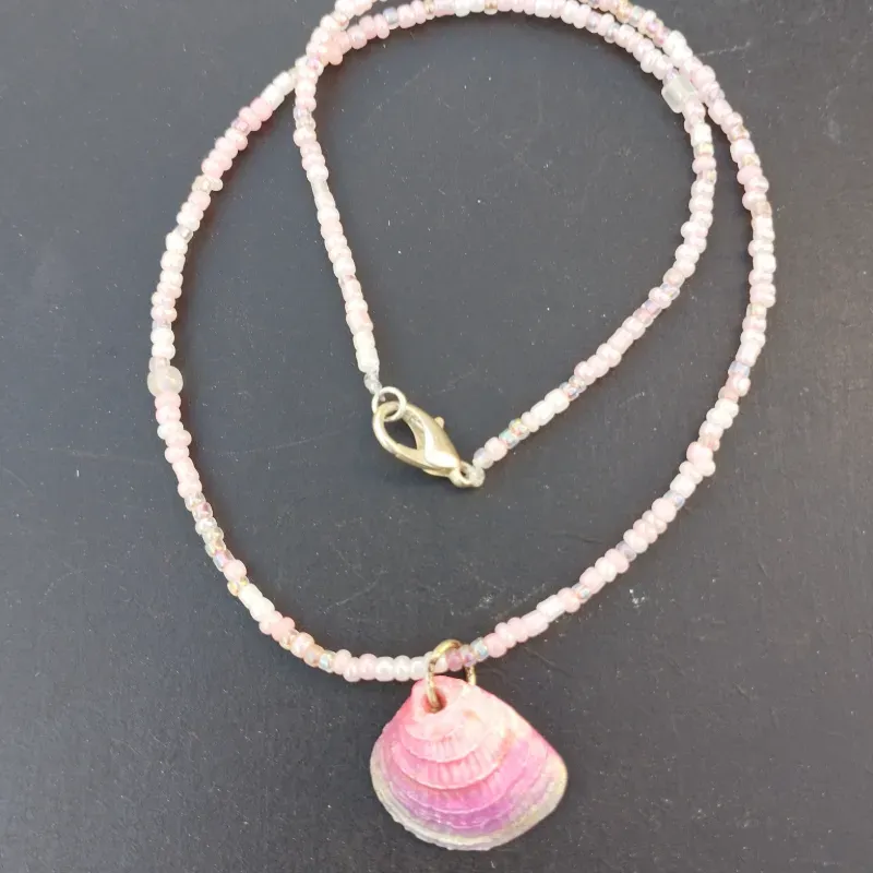 Collar rosa de mostacillas con conchas.