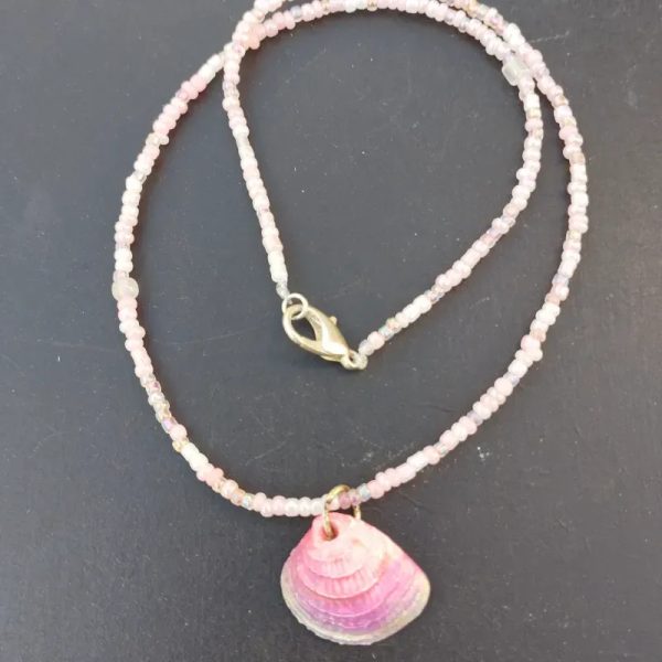 Collar rosa de mostacillas con conchas.