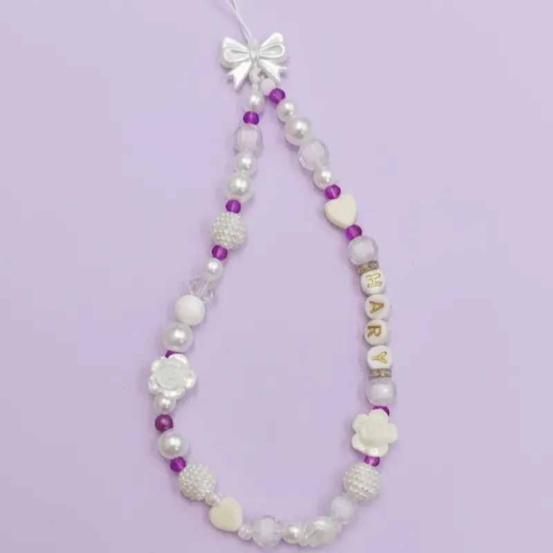 Colgante para celular en blanco y sharoski en morado.