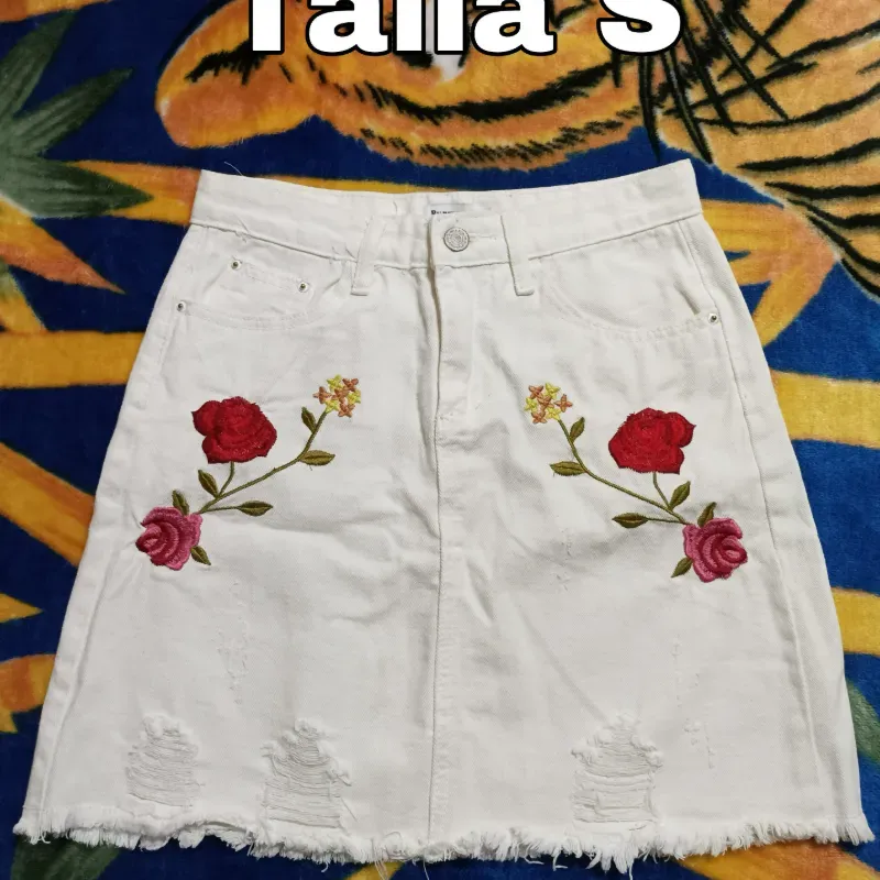 Saya blanca de mezclilla y bordados de flores.