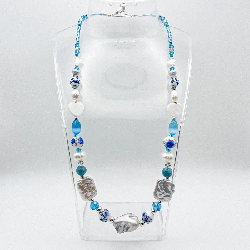 Collar de perlas naturales, artificiales, piedras semipreciosas, entre piezas de porcelana y cristales