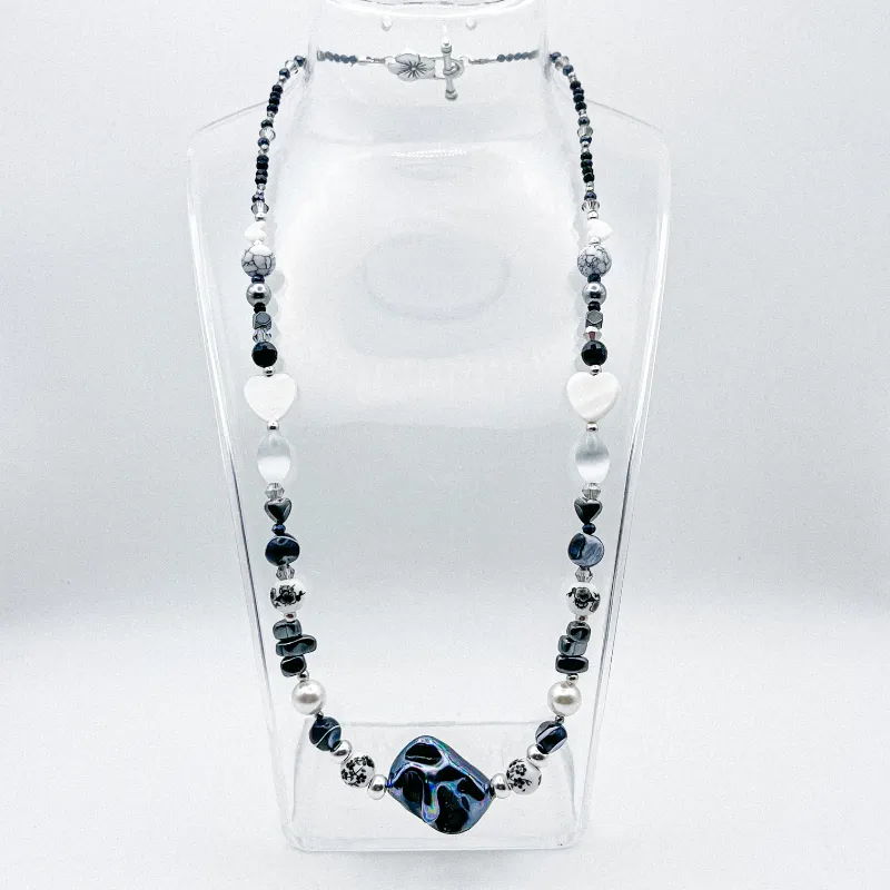 Collar de perlas naturales, artificiales, piedras semipreciosas, entre piezas de porcelana y cristales