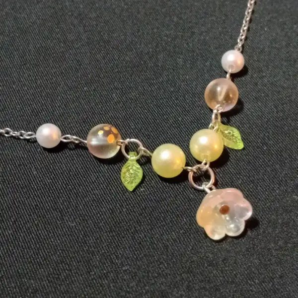 Cadena de flor con hojas y cuentas