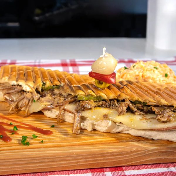 Authentica Cubano Sandwich - Roast pork topped with ham, cheese, pickle, mustard, and hot pressed. Served with slaw.