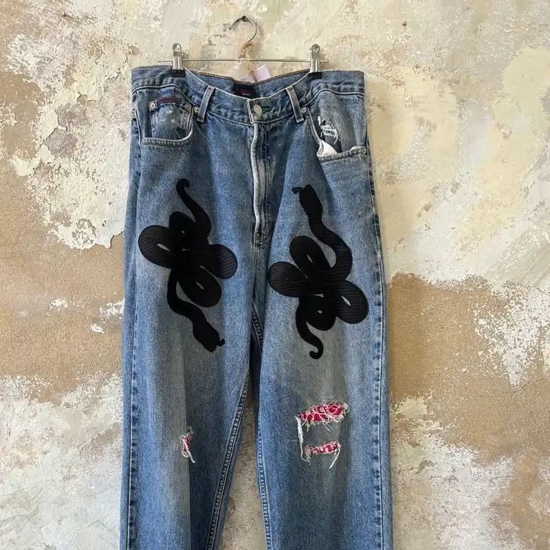Denim jeans con parches de serpiente