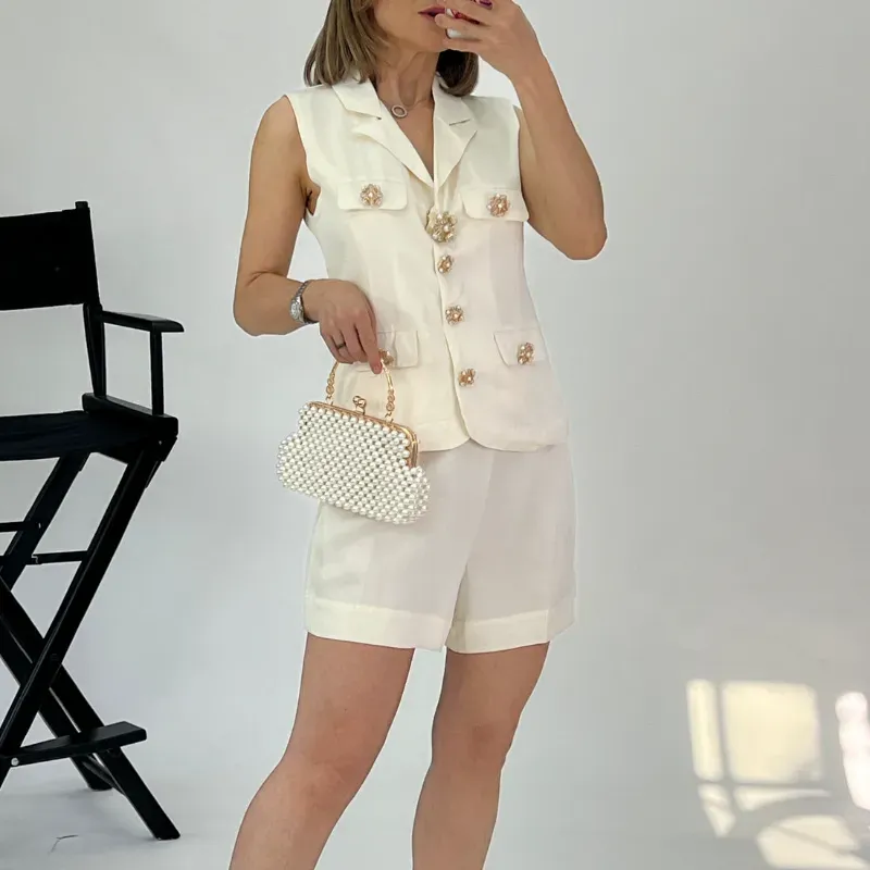 Conjunto de short y chaleco beige con broches dorados