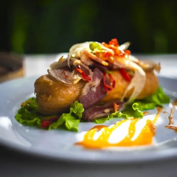 TAMAL CON CARNE, PIMIENTO, CEBOLLA Y BACON CRUJIENTE.