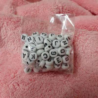 Paquete de cuentas blancas letras negras