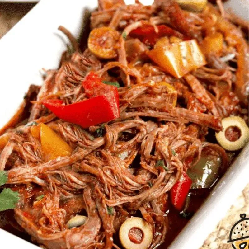 Ropa vieja con vino tinto y aceitunas