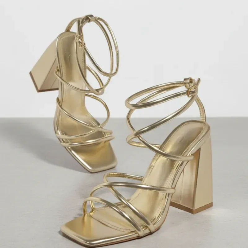 Sandalia dorada de tacón cuadrado con diseño envolvente