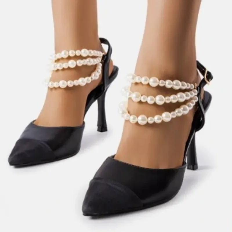 Tacones puntifinos negros con perlas blancas