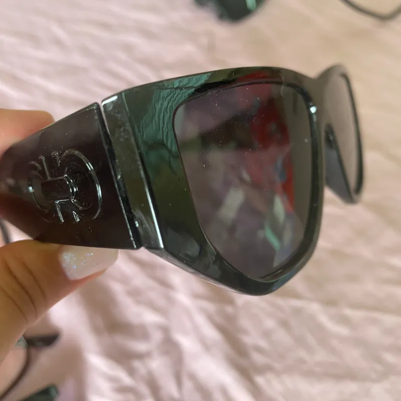 Gafas de sol con lentes oscuros y detalles en la armadura