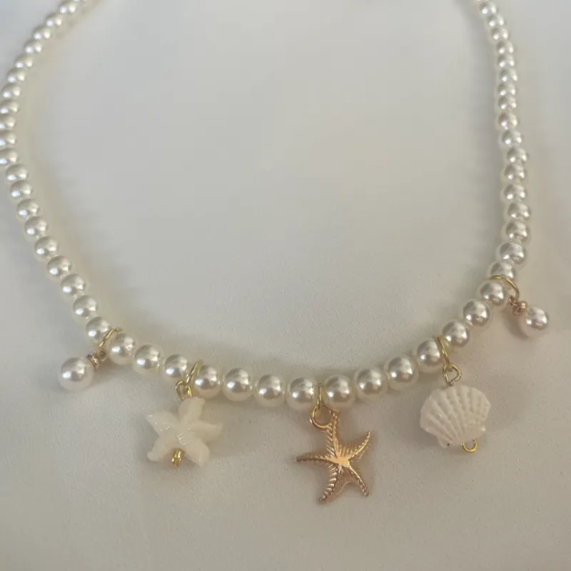 Collar de perlas con varios dijes