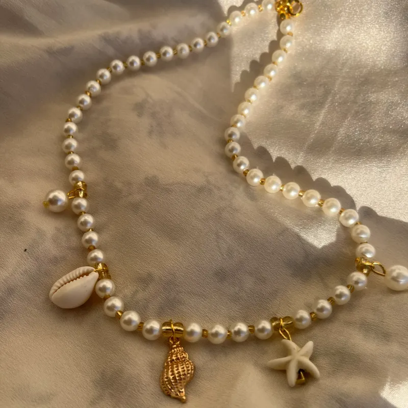 Collar de perlas con dijes