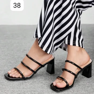 Sandalias negras de tacón cuadrado con diseño moderno y estilizado.