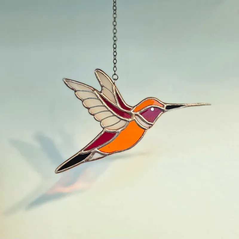 Colibrí naranja de alas abiertas