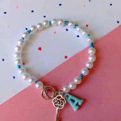 Pulsera de perlas, dije y letras
