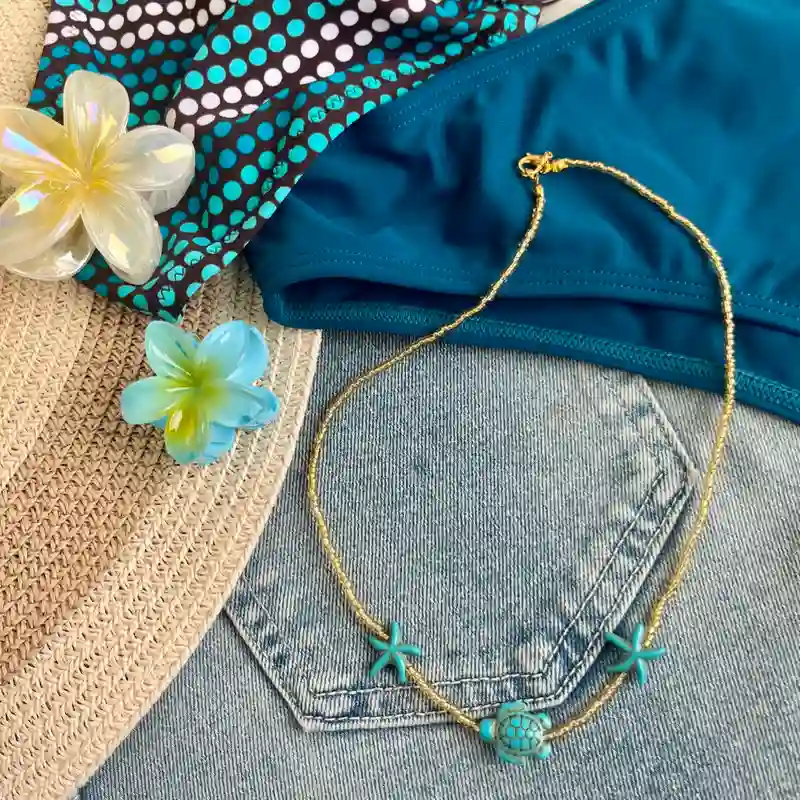Collar de cuentas doradas con estrellas de mar y tortuga