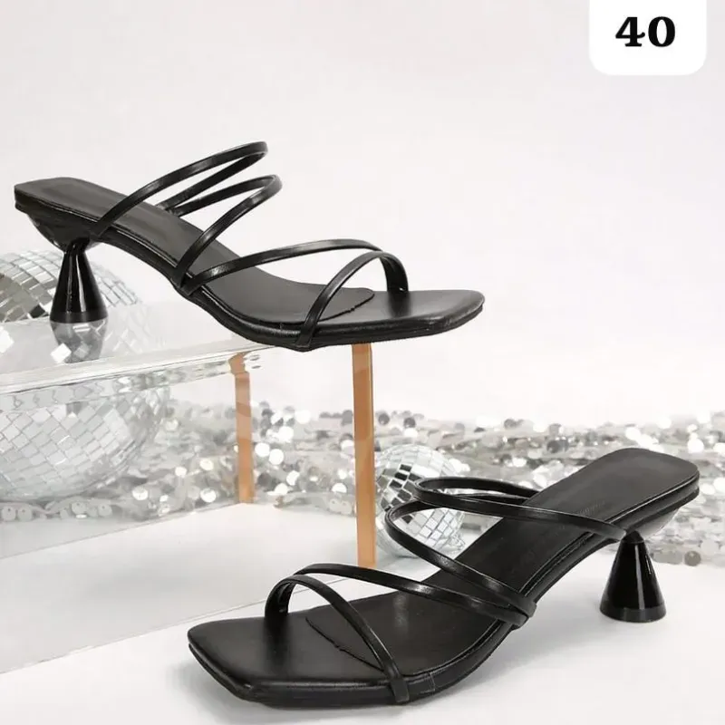 Sandalias negras de tacón alto con diseño contemporáneo y sofisticado.