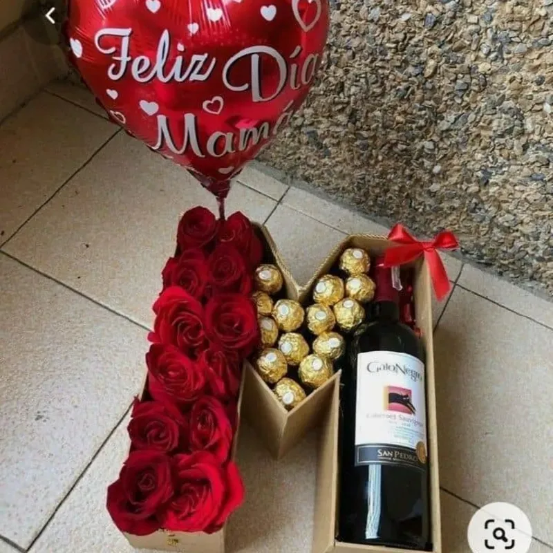 Letra con botella de vino, flores y bombones