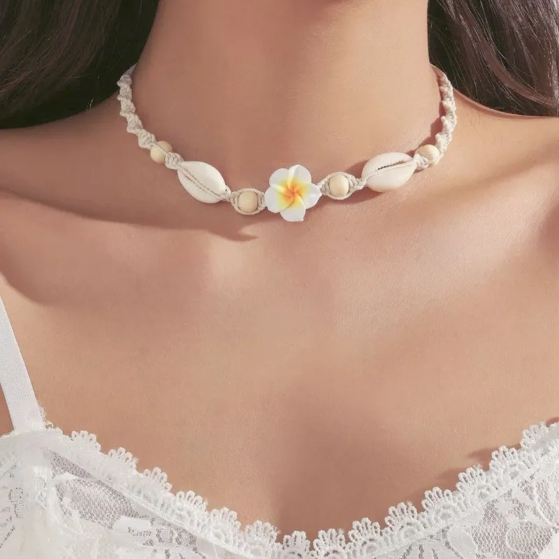 Collar de hilo tejido en espiral con caracoles y flor
